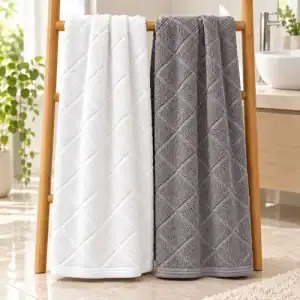 Full-size white and griffin grey bamboo bath towels with an angled woven cross design hanging in a bathroom